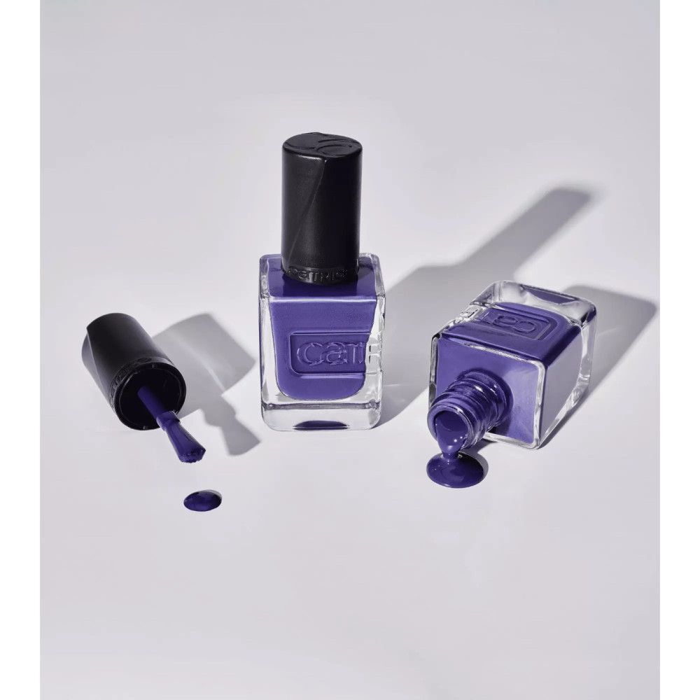 Trois flacons de vernis à ongles bleus. Un debout, deux renversés avec du vernis renversé. Marque Catrice.