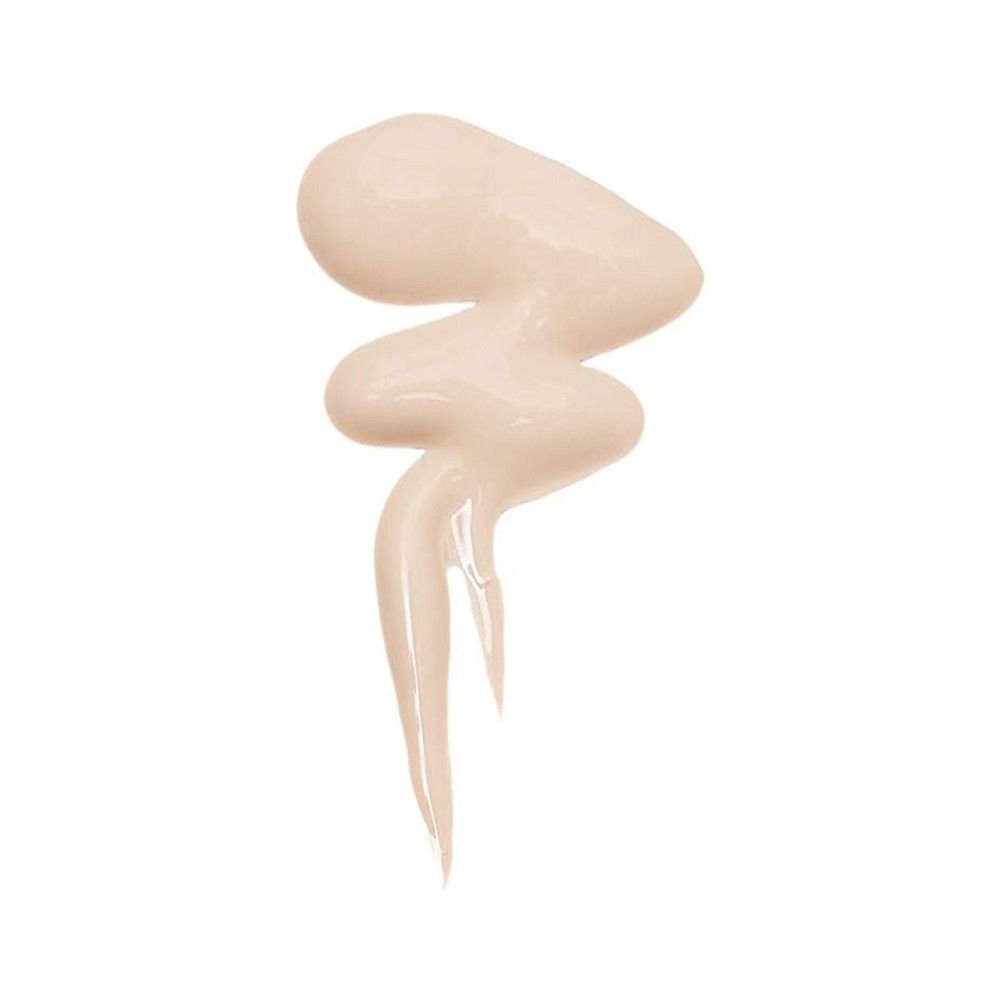 Goutte de correcteur beige en forme de vague sur fond blanc.