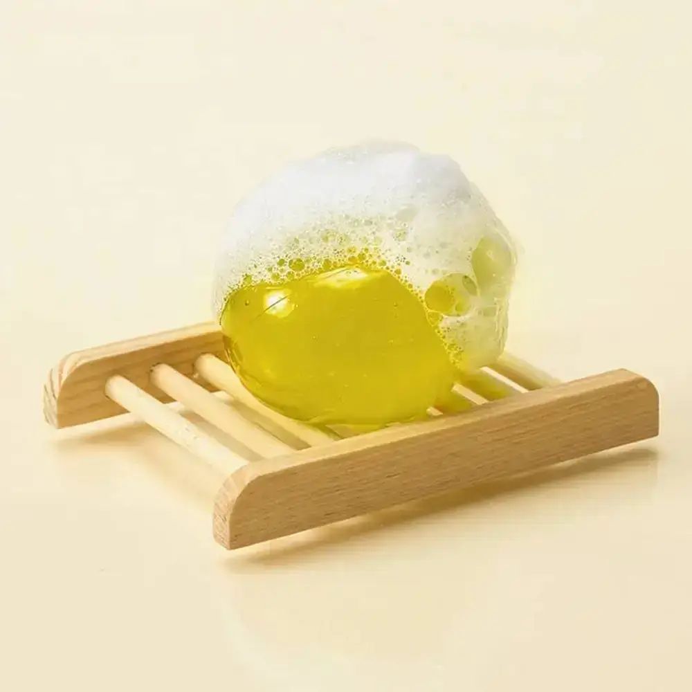 Gele bal met schuim op een houten rooster. Bovenaanzicht.