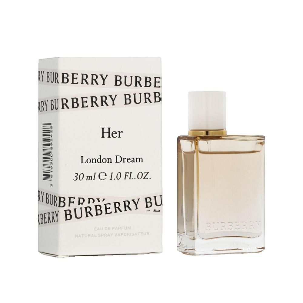 Flacon de parfum à côté d'un emballage blanc. "Her London Dream" et "BURBERRY" sur l'emballage.