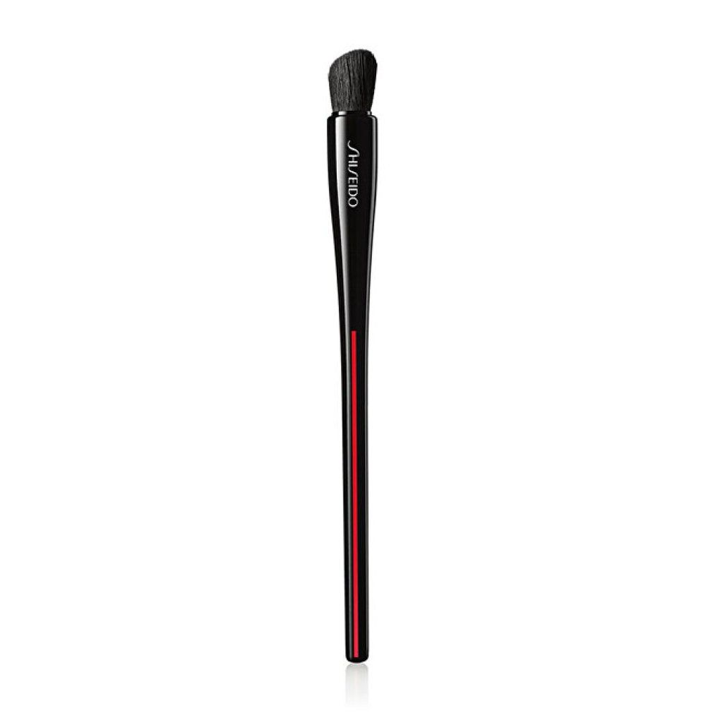Pinceau noir biseauté avec une ligne rouge. Le manche porte le nom de la marque.