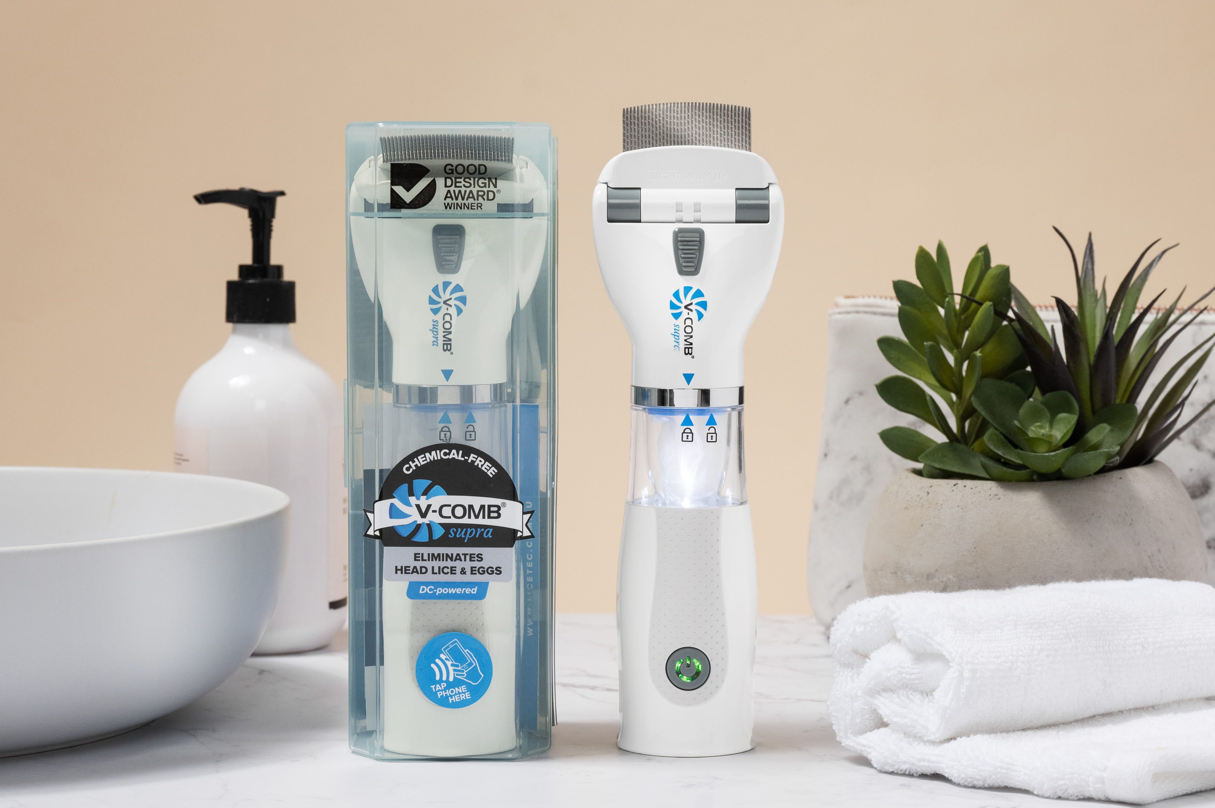 Peigne électrique anti-poux V-COMB Supra dans son étui transparent, à côté de l'appareil.