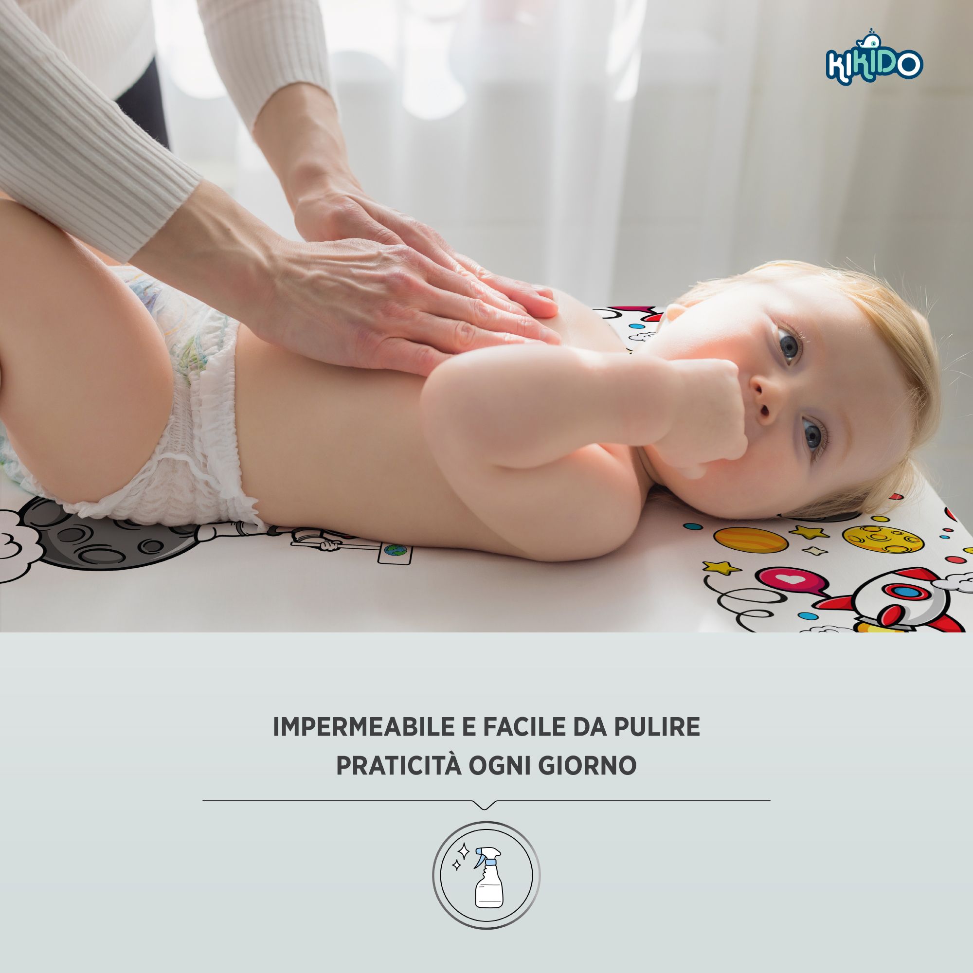 Baby op aankleedkussen met ruimtevaartmotief. Tekst: Waterdicht & gemakkelijk schoon te maken. Kikido logo.