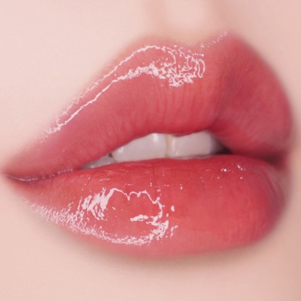 Close-up van volle, glanzende lippen. De lippen zijn roze en hebben een glanzend effect.