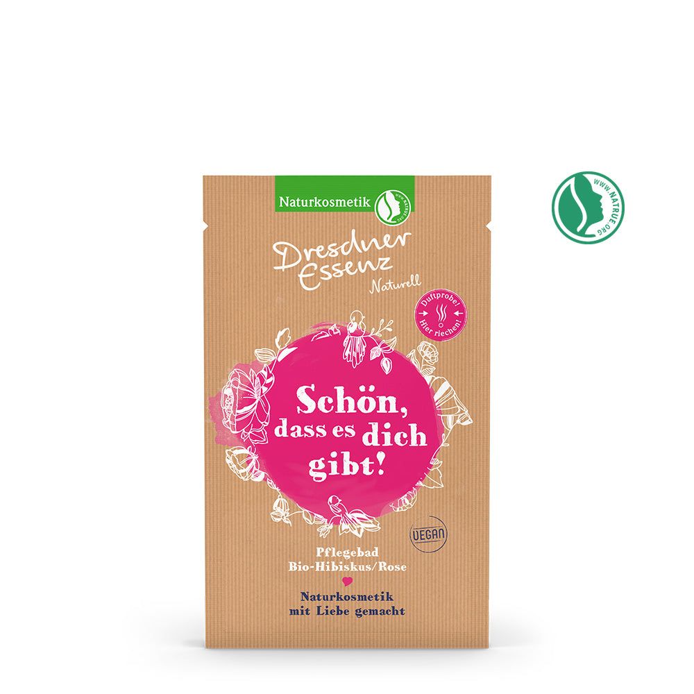Verpakking van Dresdner Essenz bad. Op bruine achtergrond staat "Schön, dass es dich gibt!". Bio-Hibiscus/Roos. Natuurlijke cosmetica.