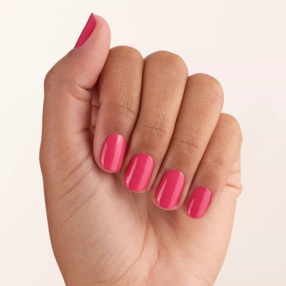Main avec ongles vernis en rose. Tous les doigts sont vernis.