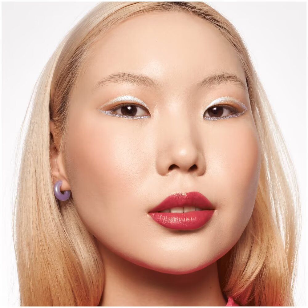 Portret van een vrouw met blush op wangen en lippen. Ze draagt lichte oogmake-up. Kijkt in de camera.
