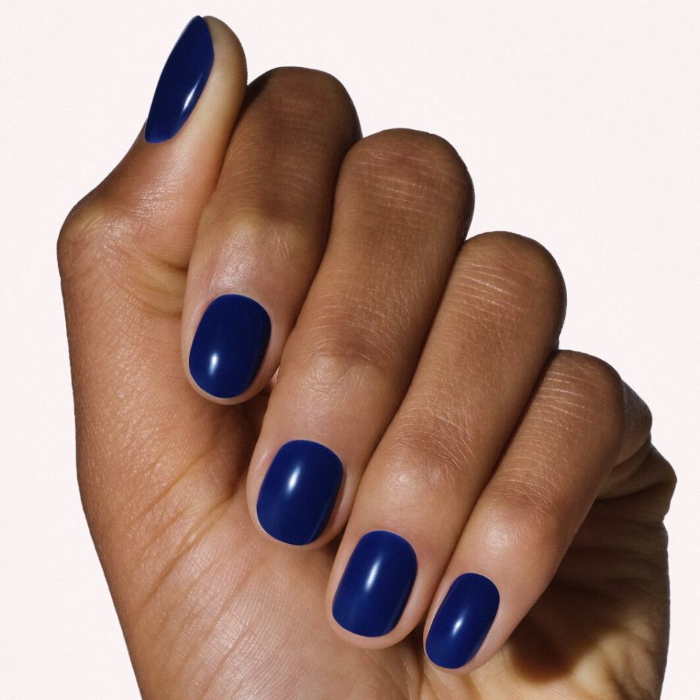 Hand met donkerblauwe, glanzende nagels.