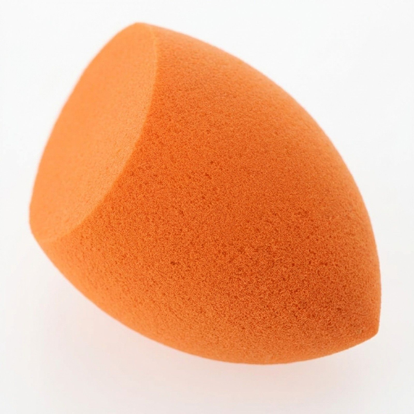 Éponge de maquillage orange avec une extrémité biseautée.