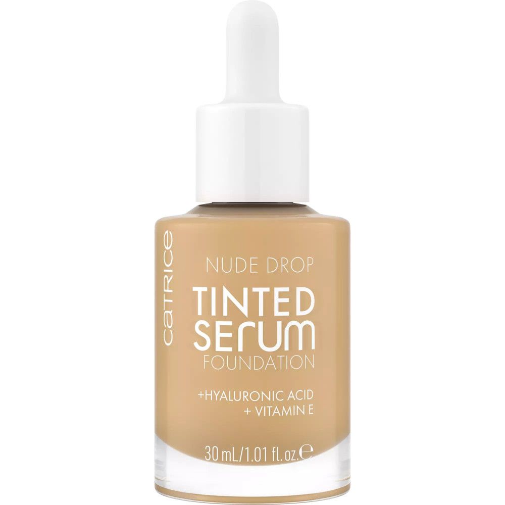 Flacon en verre de Catrice Nude Drop Sérum Teinté Foundation avec pipette. Inscription: Nude Drop, Tinted Serum Foundation, Acide Hyaluronique + Vitamine E.