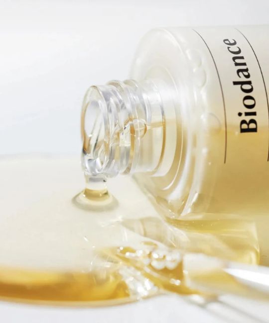 BIODANCE Skin Glow Vital Ampoule serum druppelt uit een glazen flesje. Heldere, gele vloeistof.