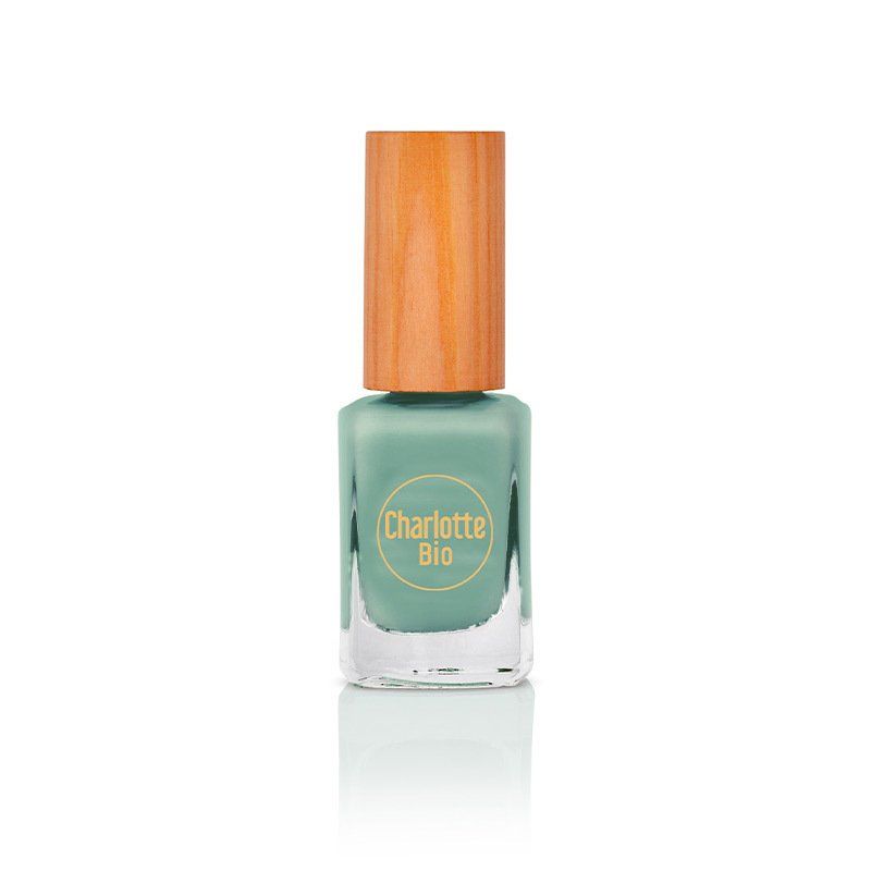 Flacon de vernis à ongles avec bouchon en bois. Le flacon porte la mention "Charlotte Bio". Le liquide est vert d'eau.