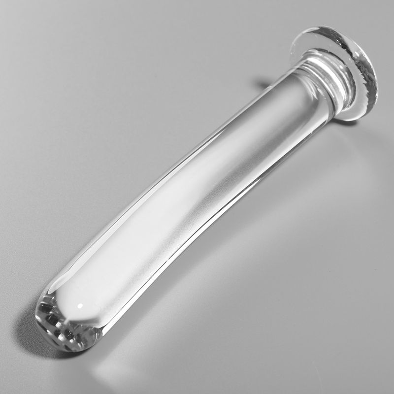Dildo transparent en verre borosilicaté, modèle 9, posé sur fond gris. Surface lisse, forme courbée, base large.