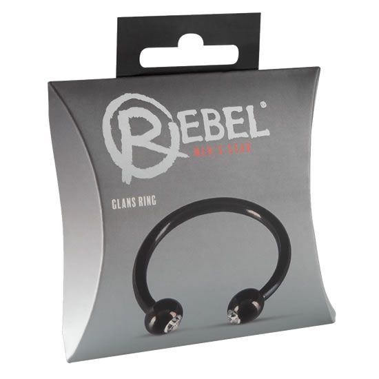 Anneau pénien noir dans son emballage. Forme annulaire avec deux boules ornées de pierres. Nom du produit visible sur l'emballage.
