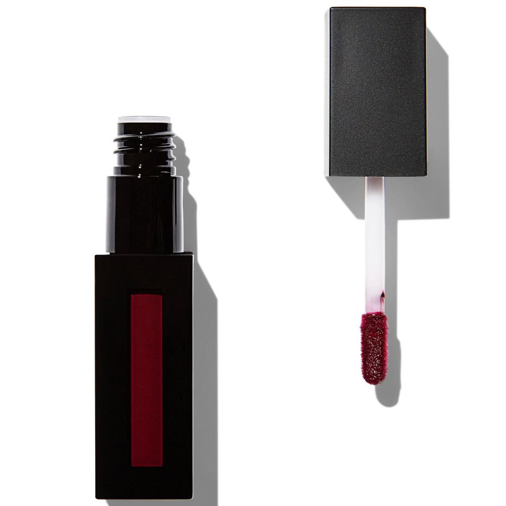 Tube de gloss noir rectangulaire avec bande rouge. Bouchon à côté, applicateur avec couleur rouge. Fond blanc.
