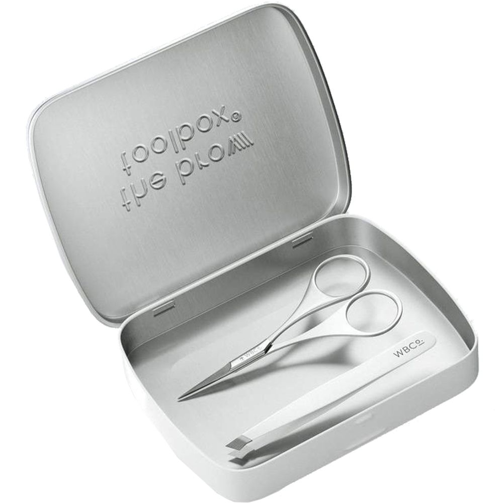 Boîte ouverte avec pince à épiler et ciseaux. Inscription "the brow toolbox". Marque : WBCo.