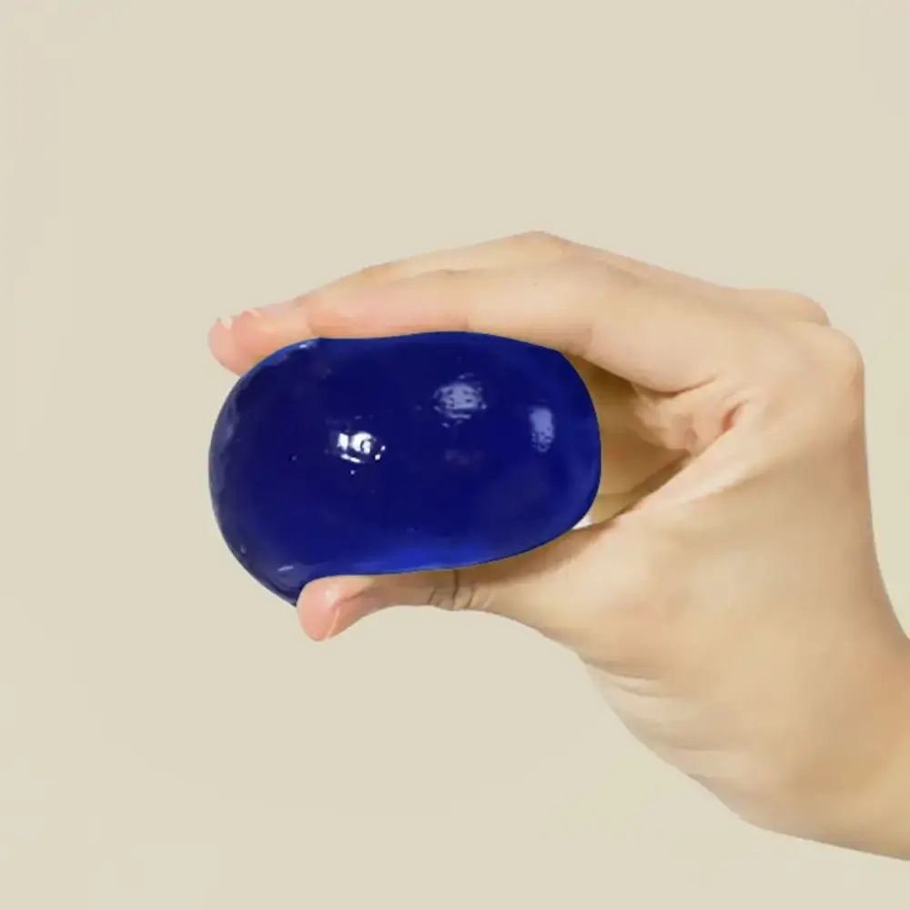 Blauwe, ovale bal in een hand. Glad oppervlak.