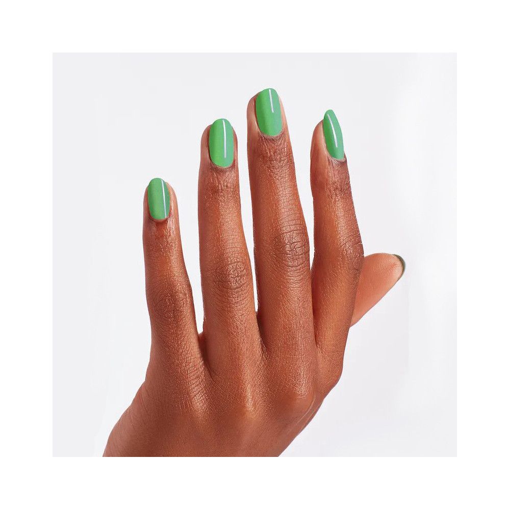Main avec ongles vernis. Vernis à ongles vert sur cinq doigts. Peau claire, fond blanc.