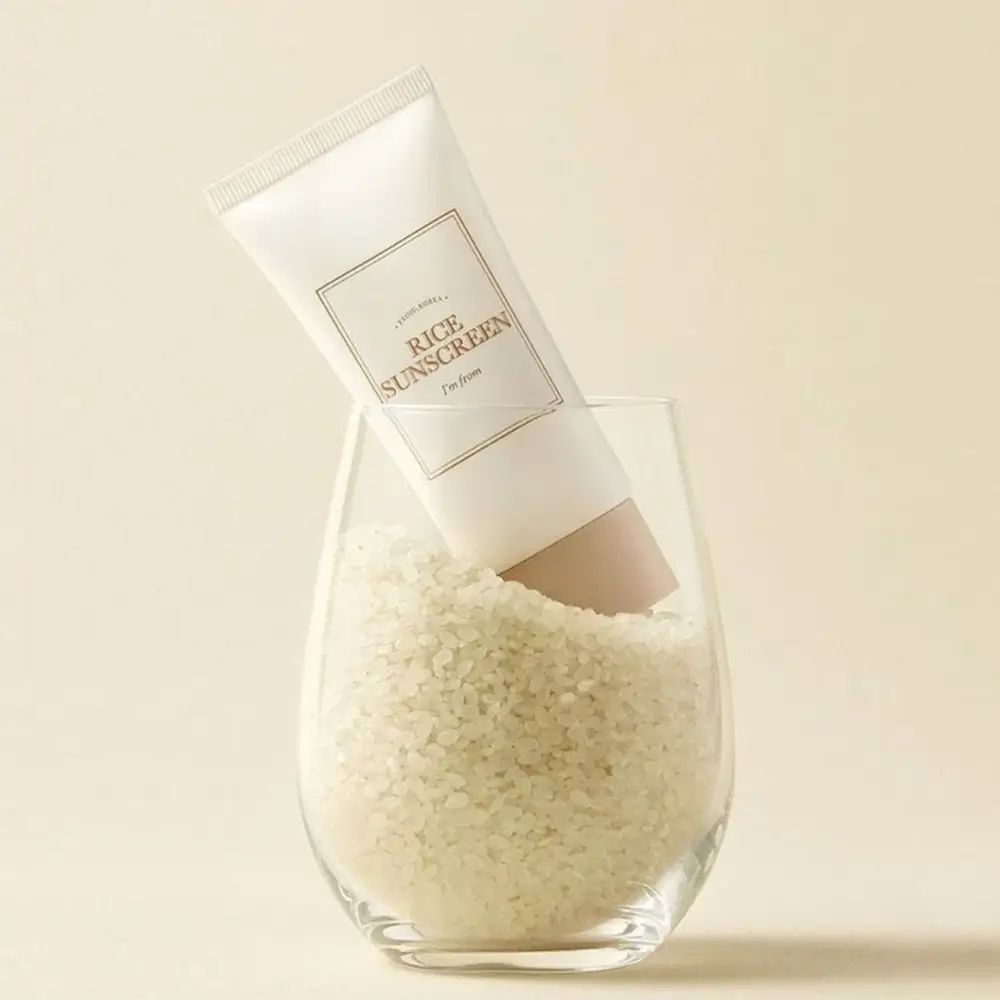 Crèmetube in glas met rijst. Opschrift 'Rice Sunscreen' en 'I'm from'. Beige dop.