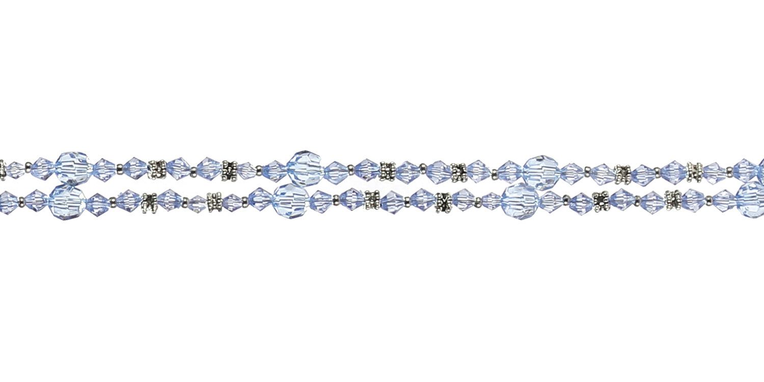 Gros plan du cordon à lunettes avec perles bleues et détails métalliques. Détails de la structure des perles visibles.