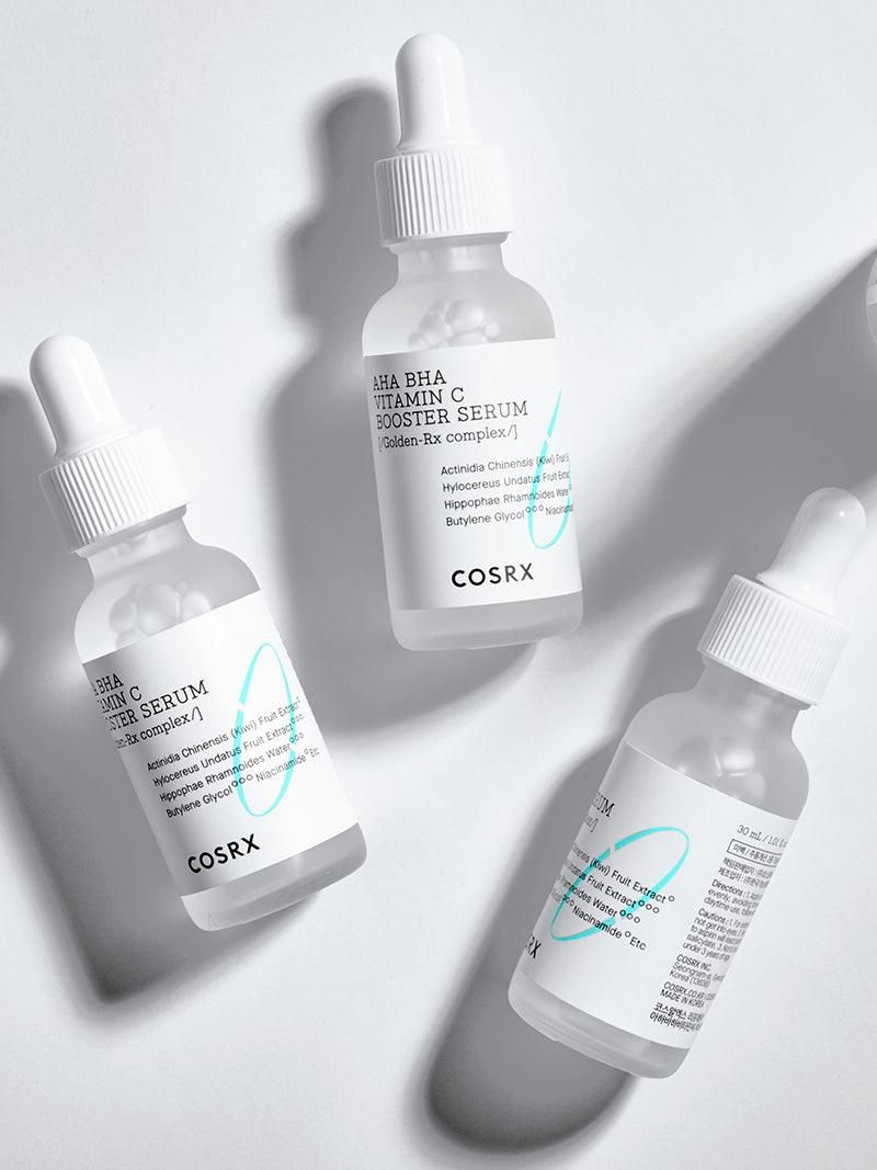 Trois flacons de sérum avec pipettes. Inscription : AHA BHA Vitamin C Booster Serum. Marque : COSRX.