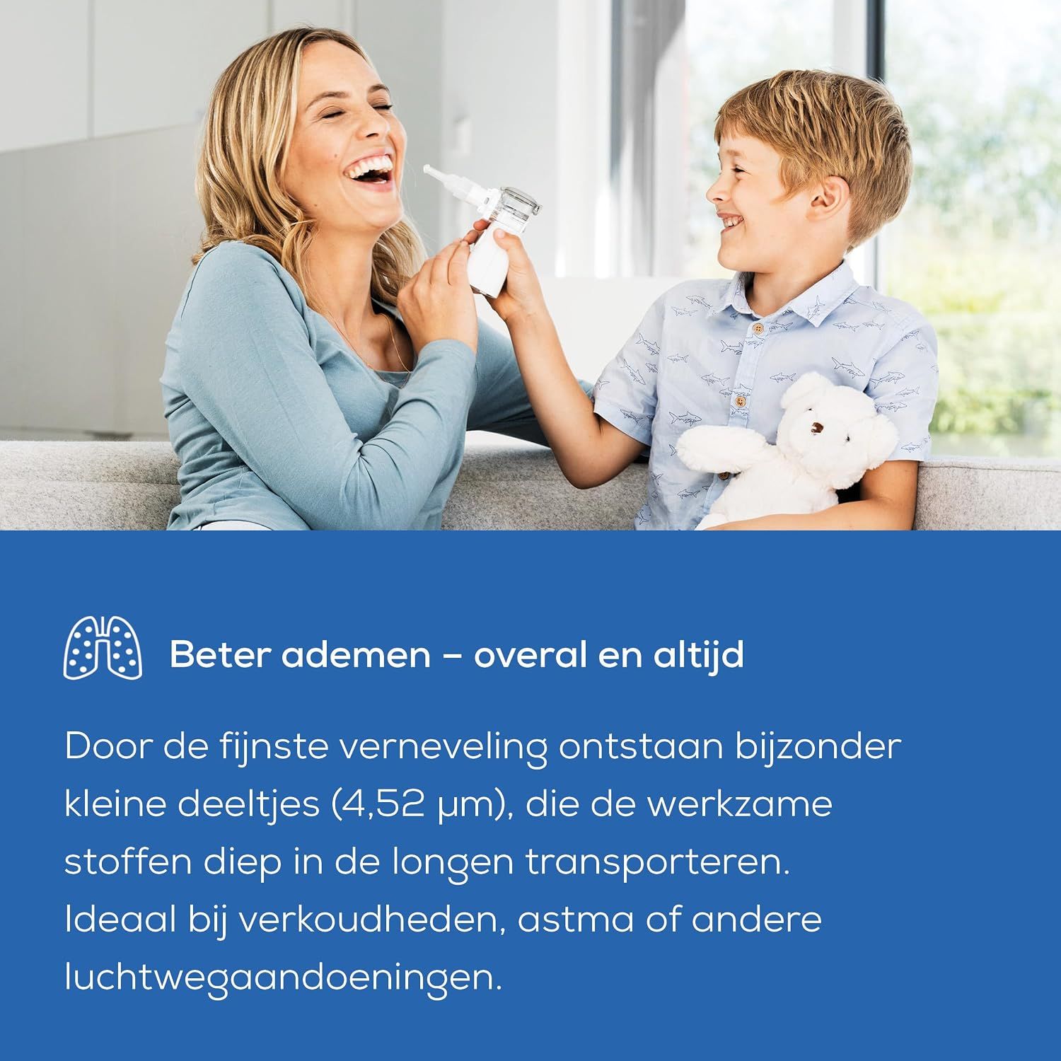 Een draagbaar vernevelapparaat in wit en grijs, vastgehouden door een vrouw en kind op een bank.