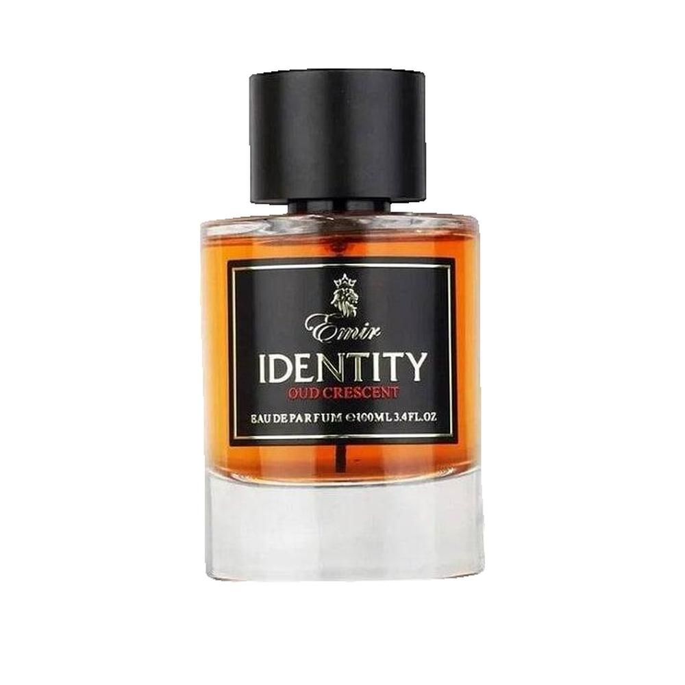 Parfumfles met zwarte dop. Zwart etiket met tekst « Emir IDENTITY Oud Crescent ». Amberkleurige vloeistof.