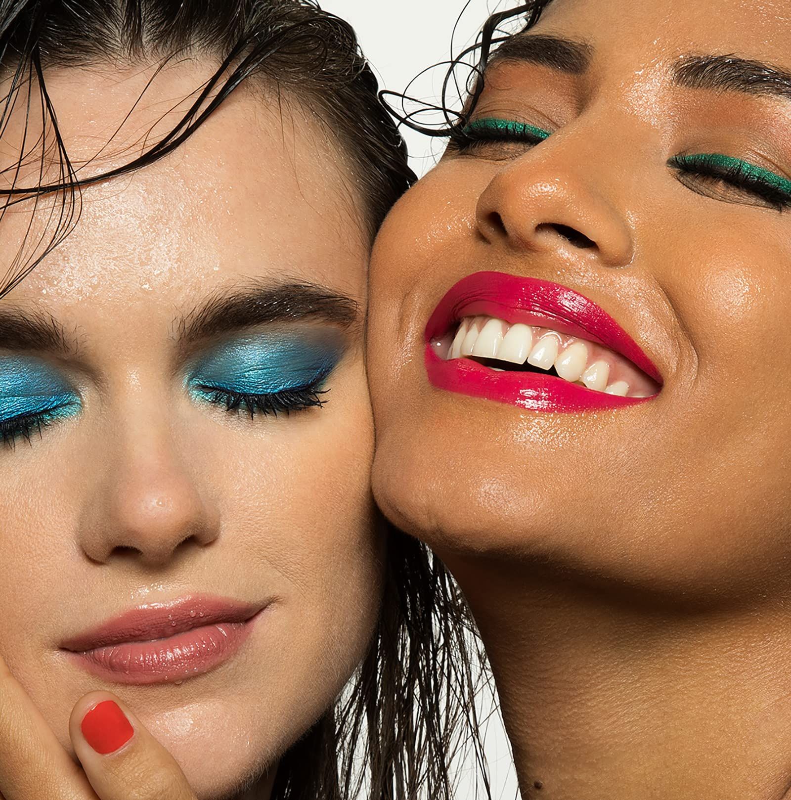 Twee vrouwen met make-up. Eén draagt blauwe, de ander groene oogschaduw en roze lippenstift.