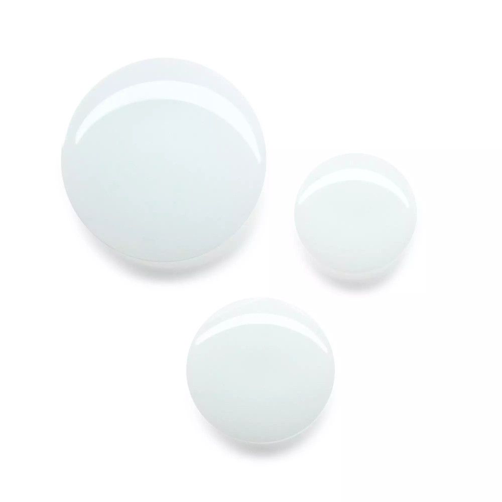 Drie witte, ronde druppels op een witte achtergrond. De druppels zijn verschillend van grootte en glanzend.