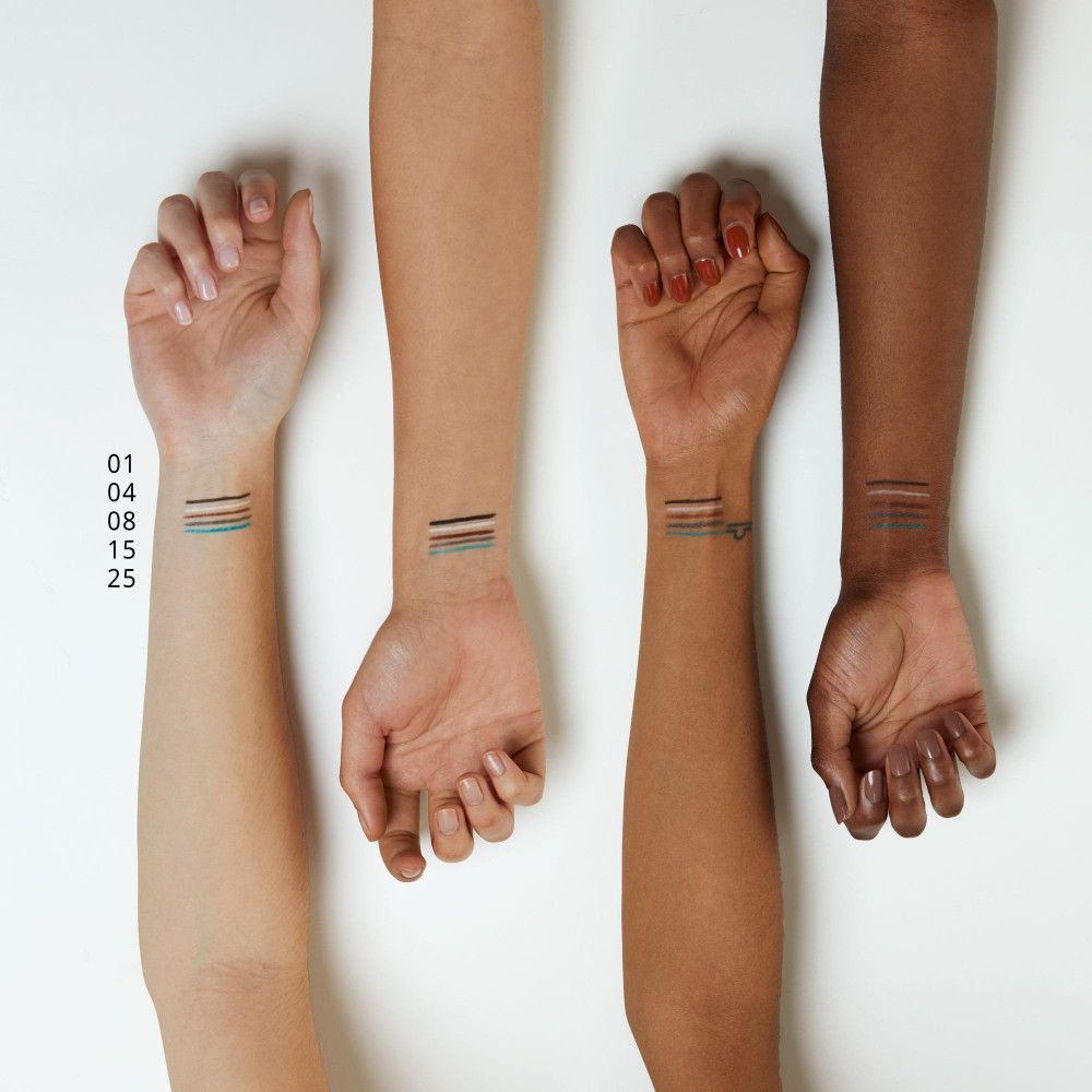 Quatre bras de différentes couleurs de peau. Des traits de Kajal de différentes couleurs sont appliqués sur les poignets.