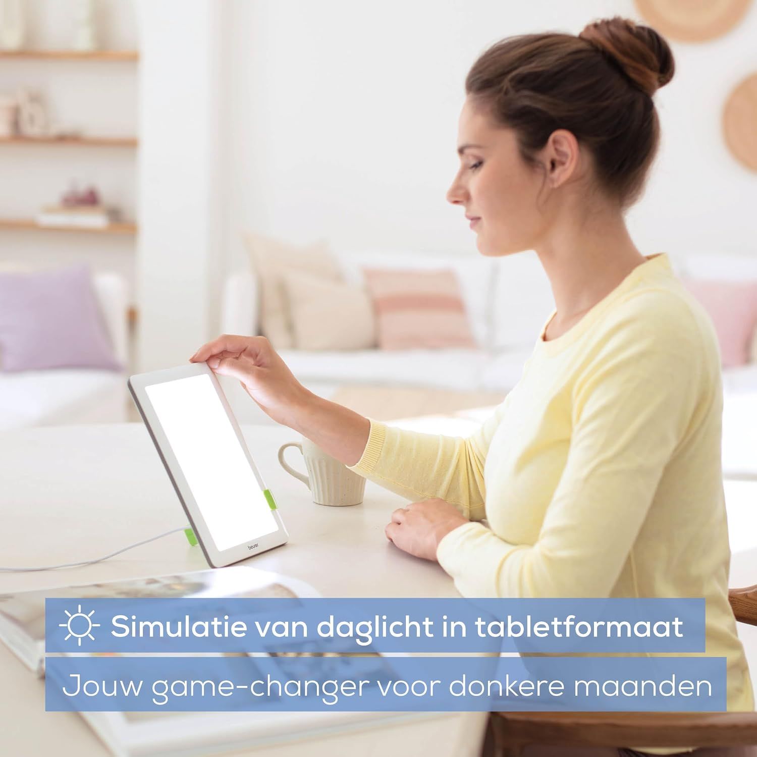 Een vrouw gebruikt een heldere lichttherapielamp in tabletformaat.