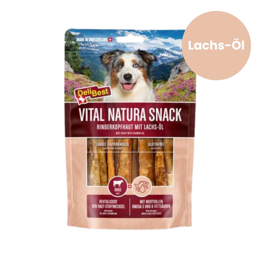 Verpakking DeliBest Vital Natura Snack. Runderkopshuid met wilde zalmolie. Afbeelding van een hond. Tekst: Vital Natura Snack, Rinderkopfhaut mit Lachs-Öl.