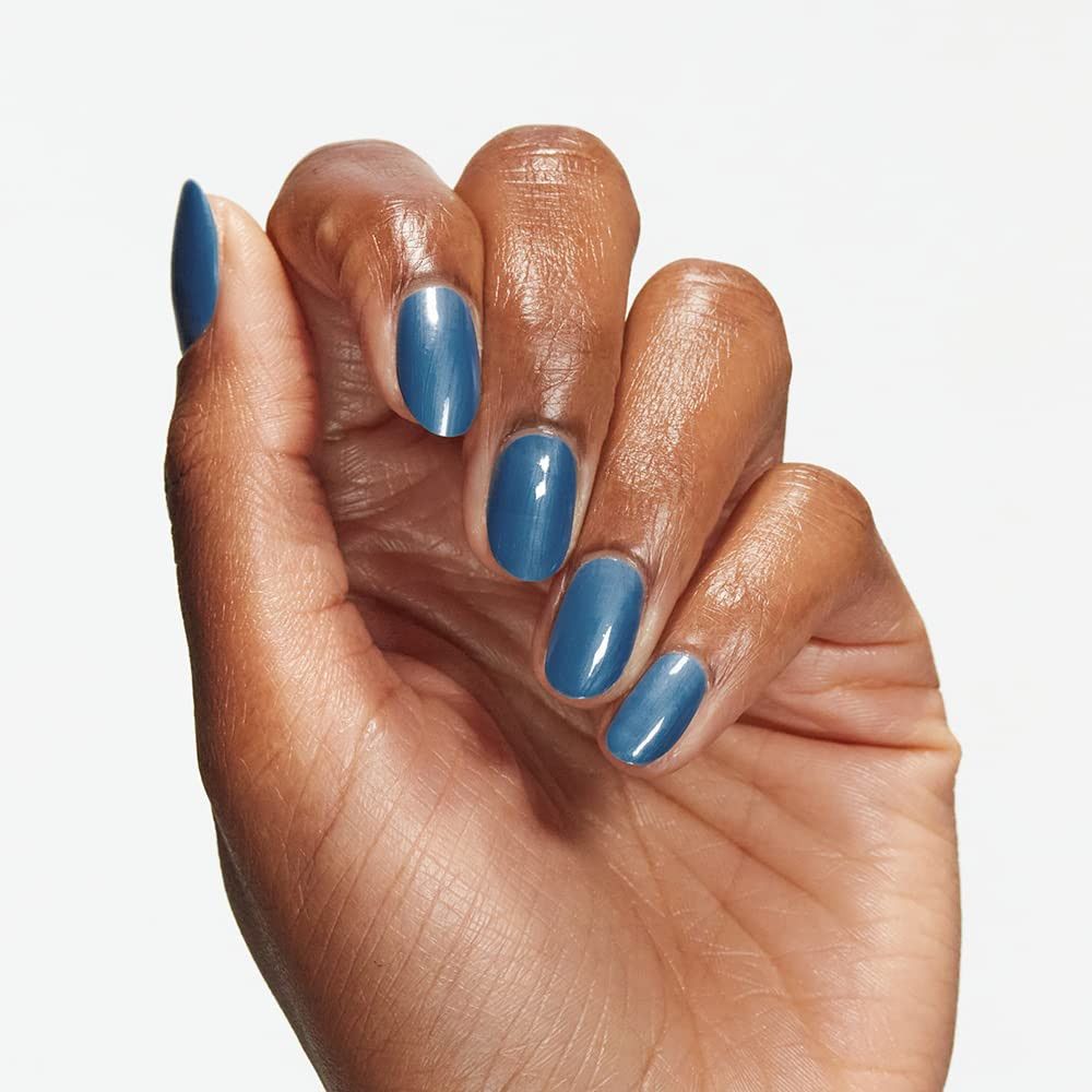 Main avec des ongles peints en bleu. Gros plan, peau claire.