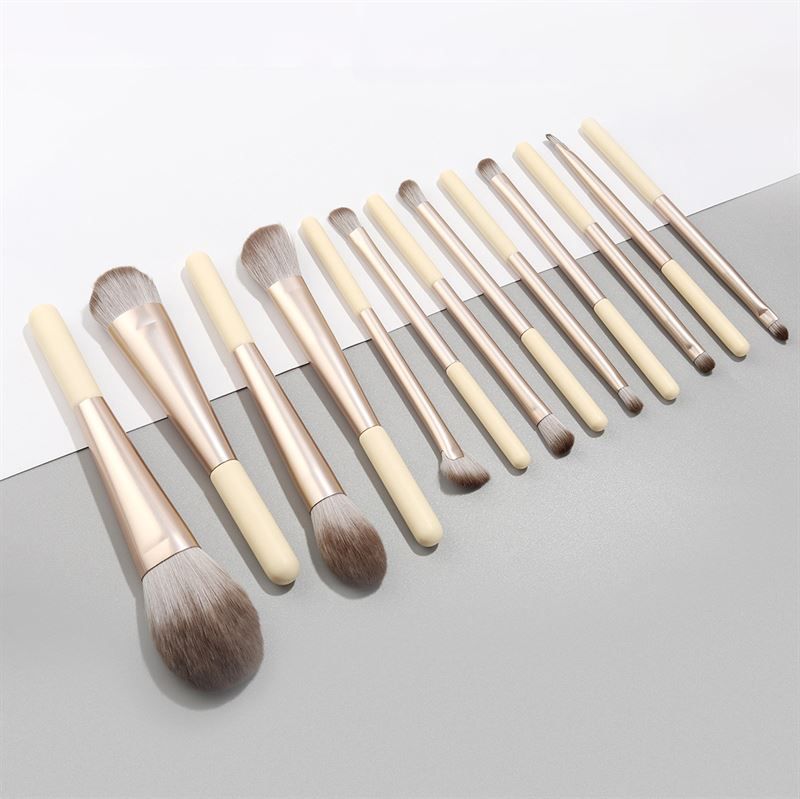 12 pinceaux de maquillage avec manches crème et viroles argentées. Différentes formes de têtes.