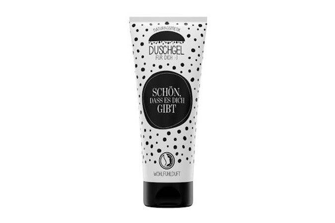 Tube de gel douche blanche à pois noirs. Cercle noir avec texte: Schön, dass es Dich gibt. Bouchon noir.