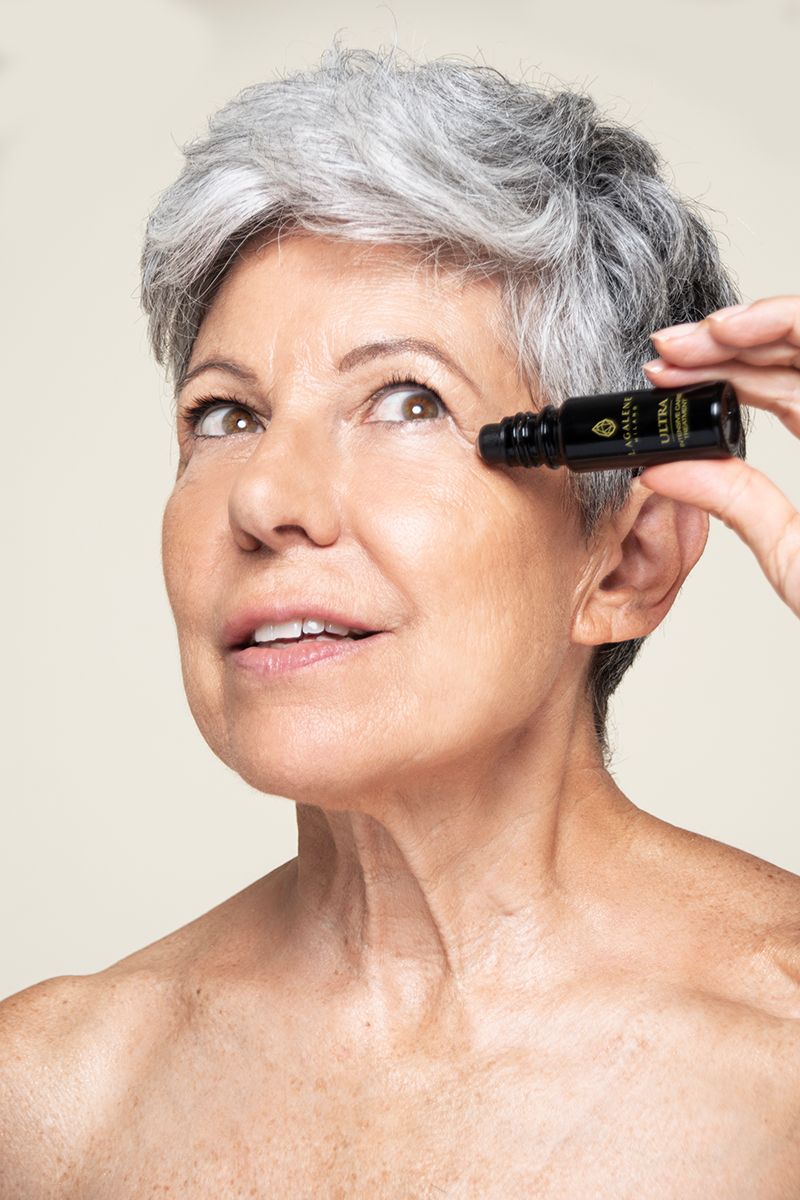 Een vrouw houdt een Lagalene Milano Ultra Intensive Care fles met roll-on applicator bij haar oog. Op de fles staat "ULTRA INTENSIVE TREATMENT".