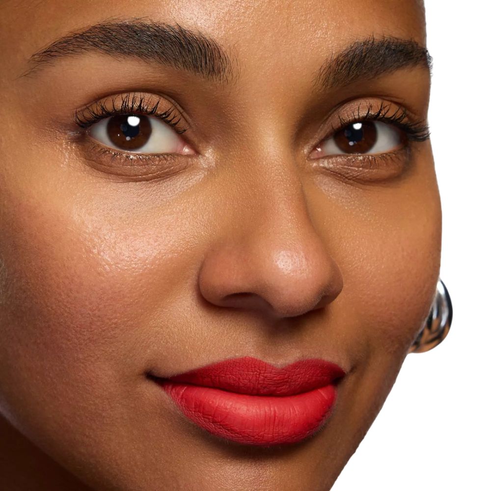 Gros plan d'un visage avec rouge à lèvres rouge. Peau foncée, yeux bruns, boucles d'oreilles argentées.