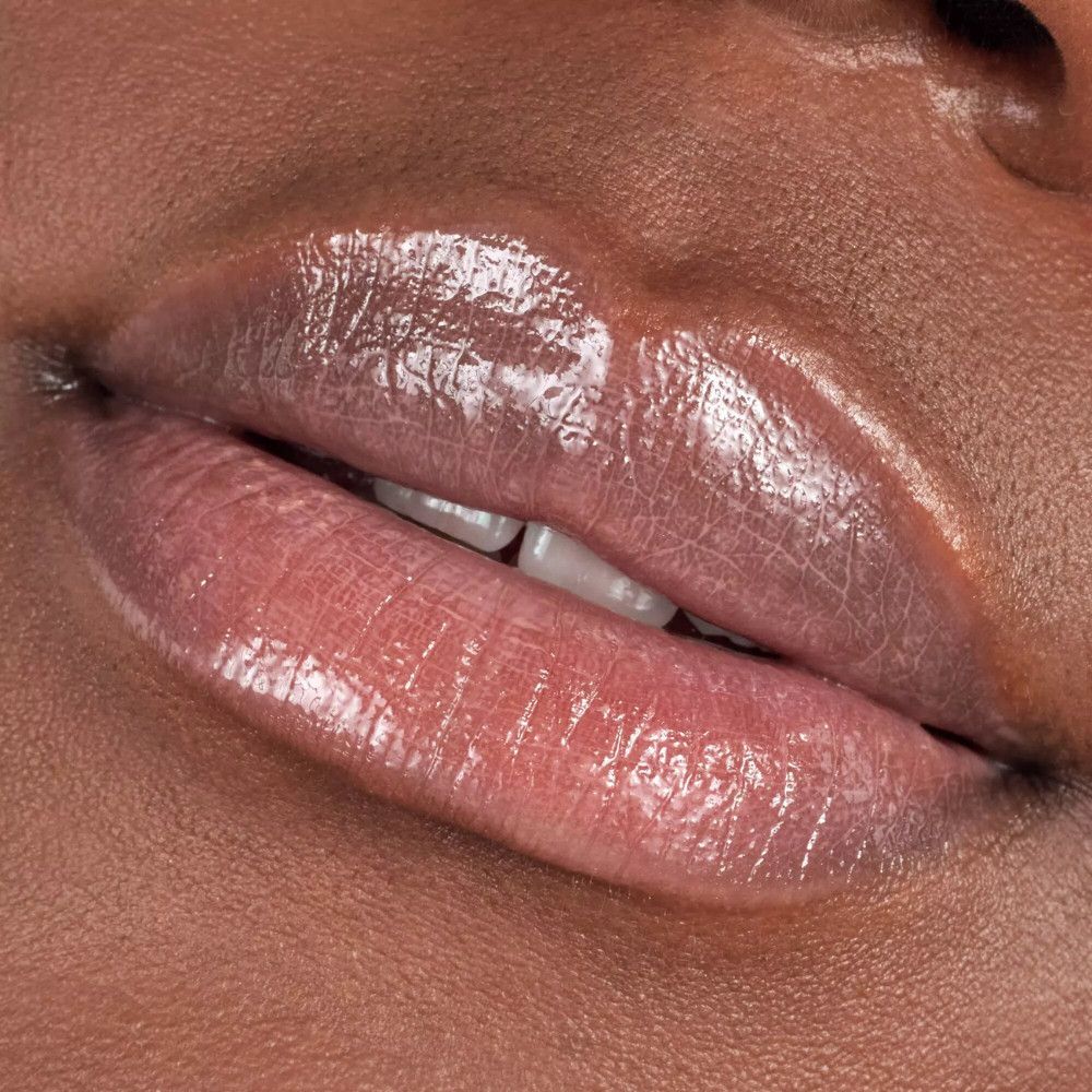 Close-up van lippen bedekt met glanzende lipgloss. Huidskleur.