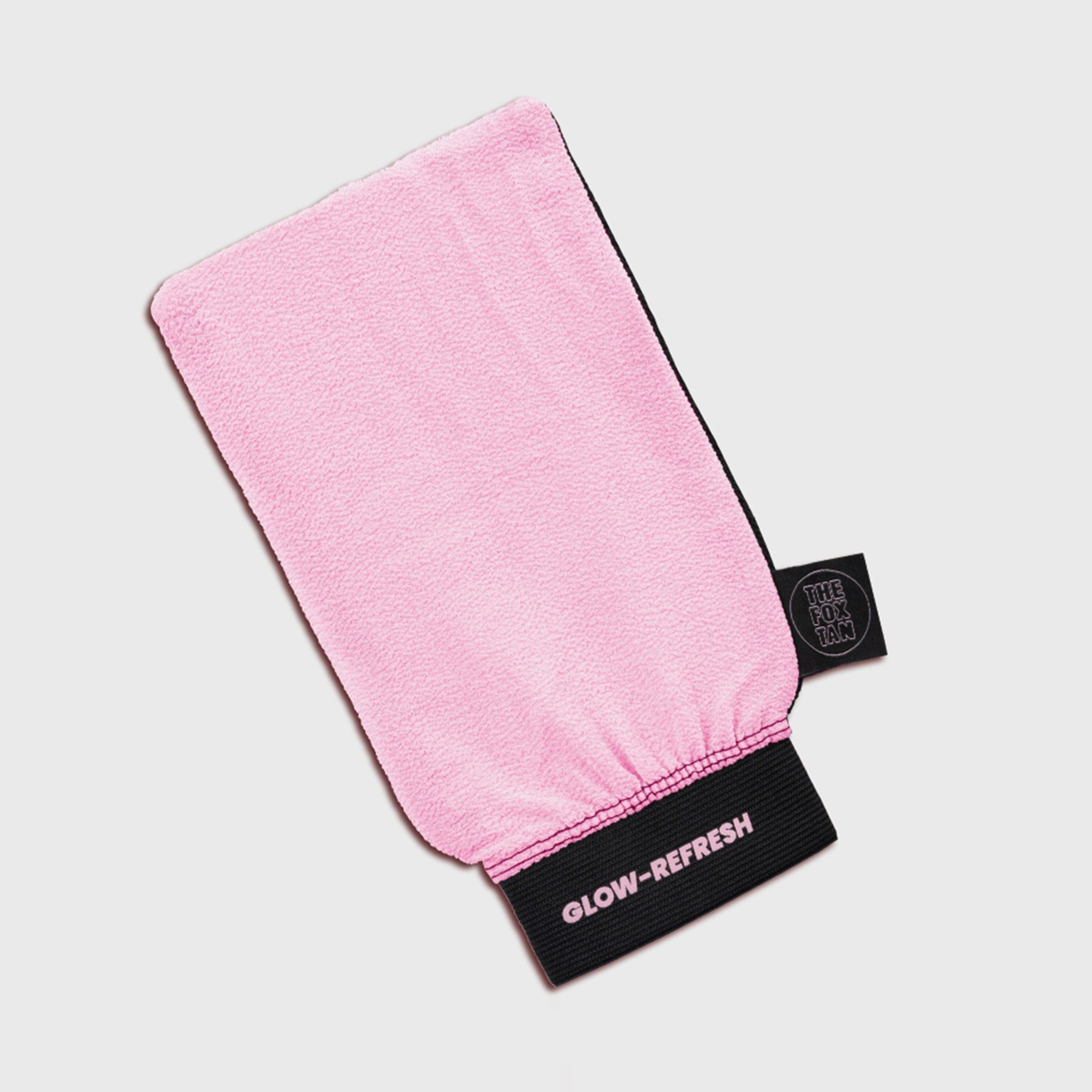 Gant exfoliant rose avec bord noir et texte. Vue du produit de dessus.