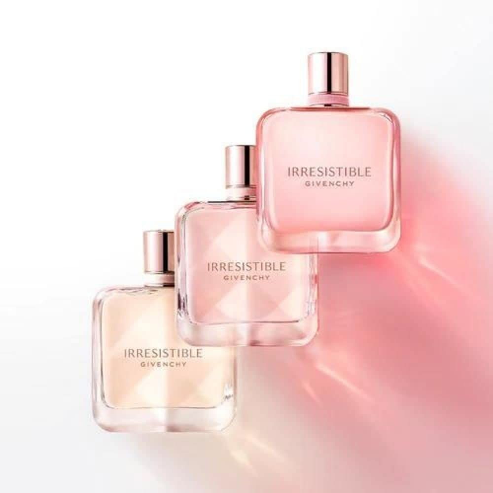 Drie roze parfumflacons. Opschrift: Irresistible Givenchy. Rechthoekige flacons met roze inhoud en roségouden doppen.