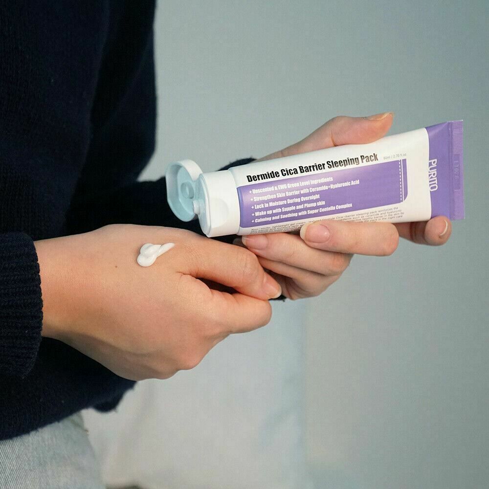 Handen houden tube vast. Crème wordt op de handpalm aangebracht. Merk PURITO. Tekst: Dermide Cica Barrier Sleeping Pack.
