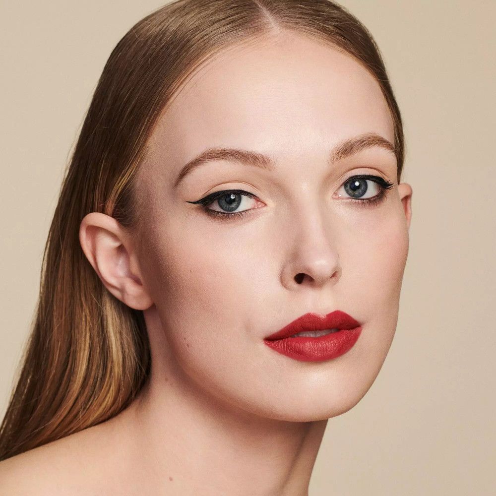 Portret van een vrouw met rode lippenstift. Blond haar, blauwe ogen, eyeliner.