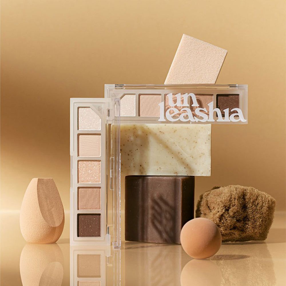 Plusieurs palettes de maquillage UNLEASHIA Mood Shower, éponges et blocs. Les palettes sont transparentes et contiennent des fards à paupières.