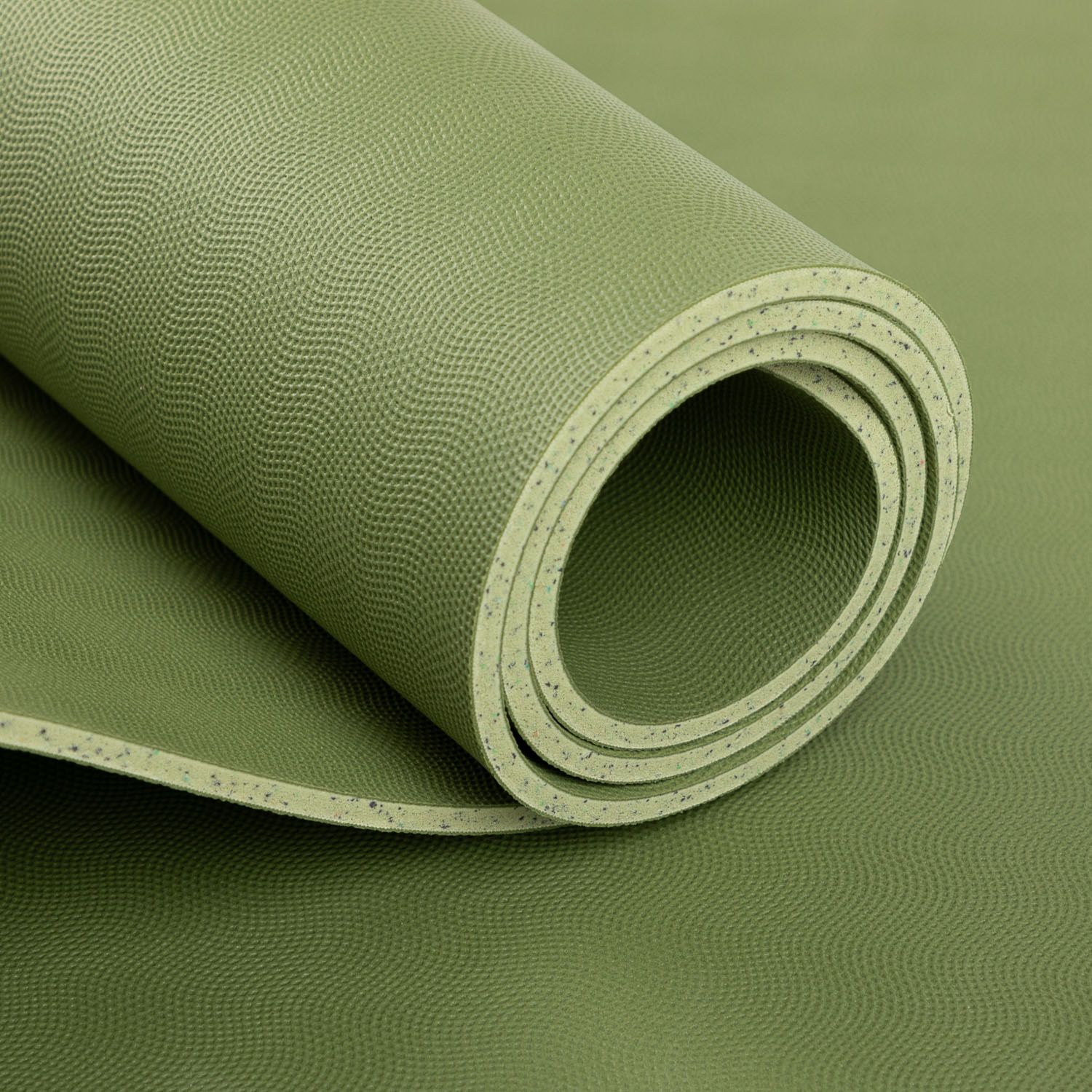 Opgrolde groene yogamat. Detailweergave van het oppervlak. Natuurrubber. Op witte achtergrond.