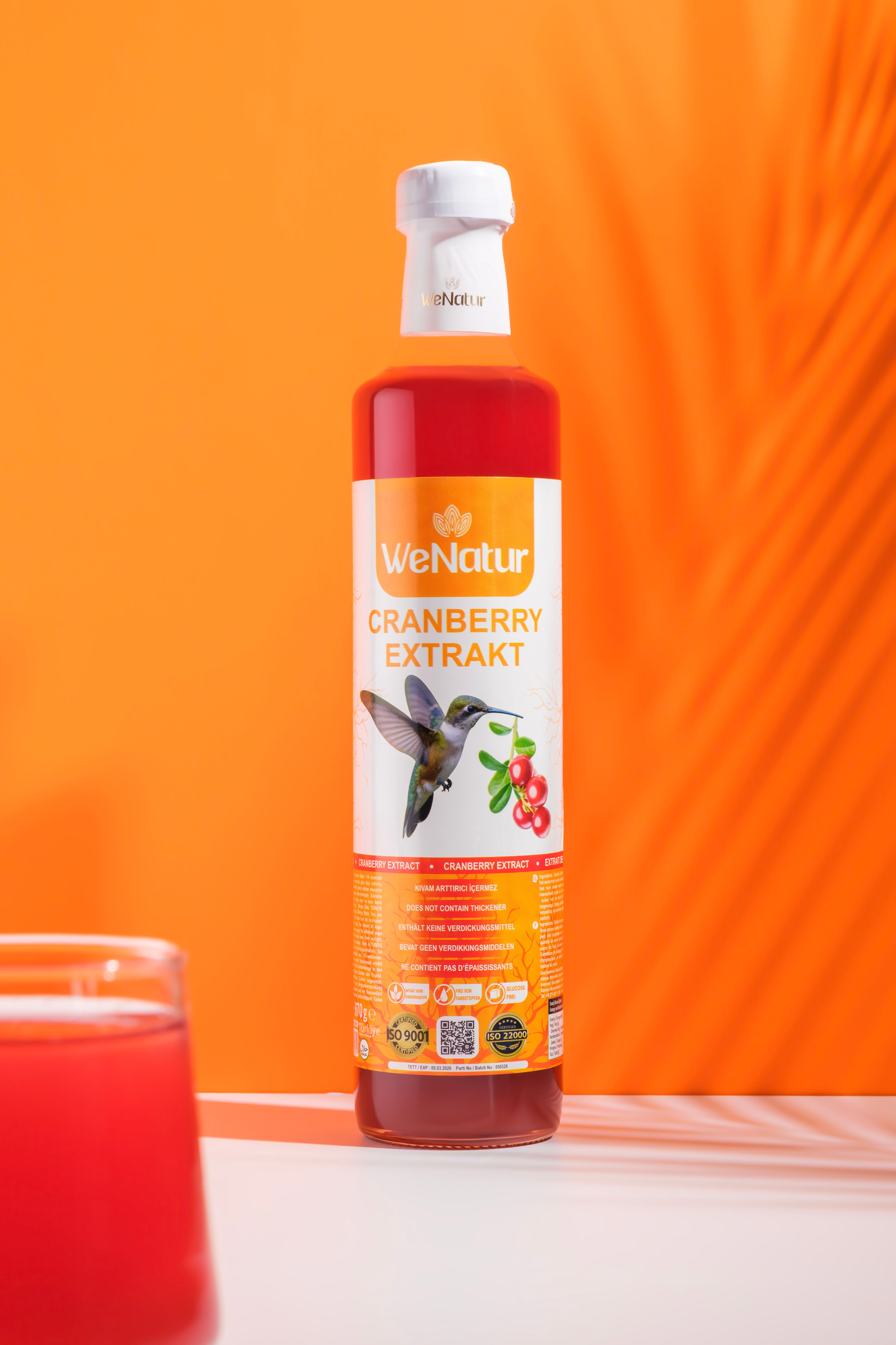 Bouteille d'extrait de canneberge, étiquette avec colibri et baies.