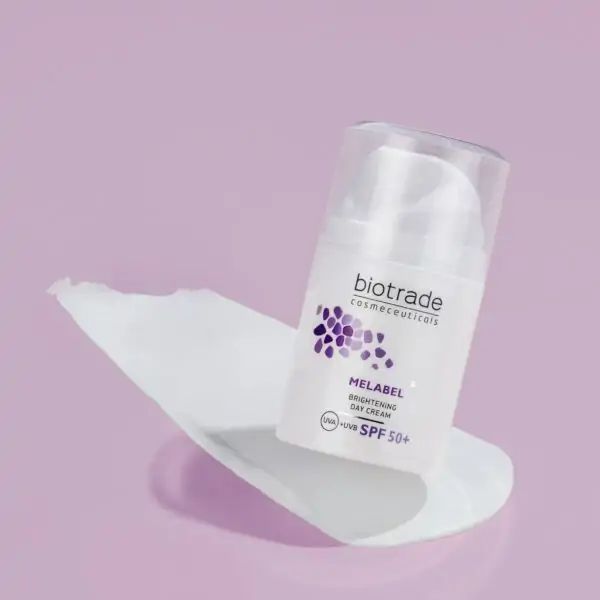 Witte Biotrade Melabel dagcrème op witte ondergrond. Opschrift: Melabel Brightening Day Cream SPF 50+. Paars logo en tekst.