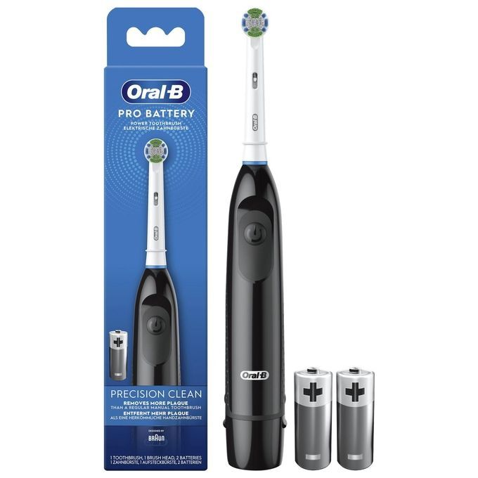 Brosse à dents électrique dans son emballage. Manche noir, tête blanche avec poils verts. Deux piles. Emballage avec image et texte du produit.