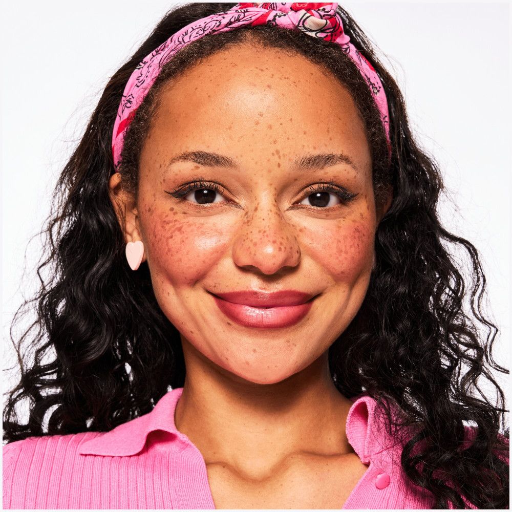 Portret van een vrouw met lippenstift. Roze haarband en top. Productpresentatie.