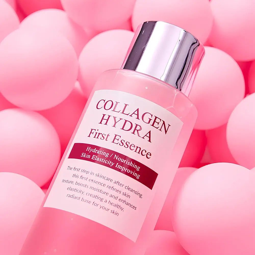 Flesje "Collagen Hydra First Essence" omringd door roze ballen.