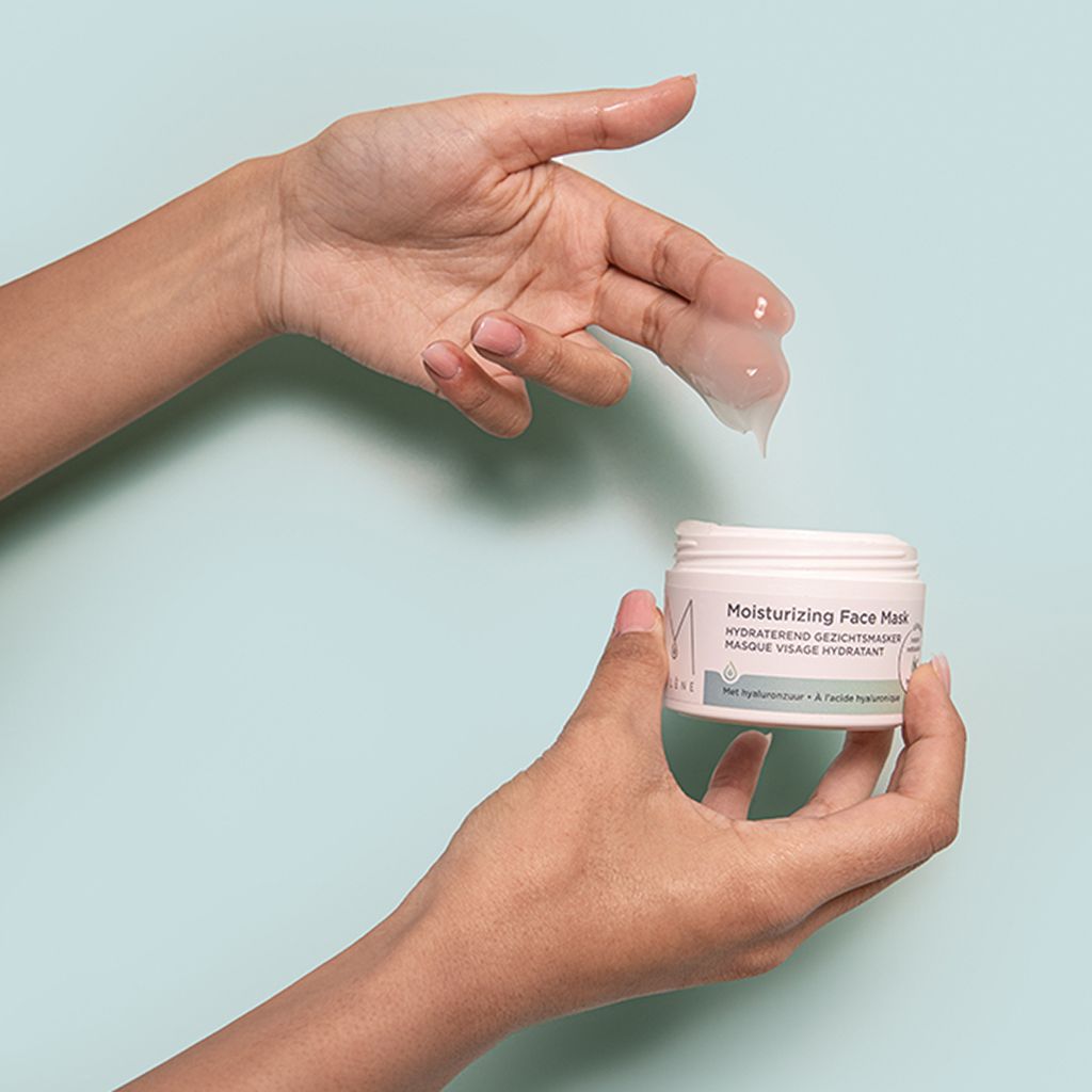 Handen houden pot en gel-gezichtsmasker vast. Gel druppelt uit de hand. Opschrift "Moisturizing Face Mask".